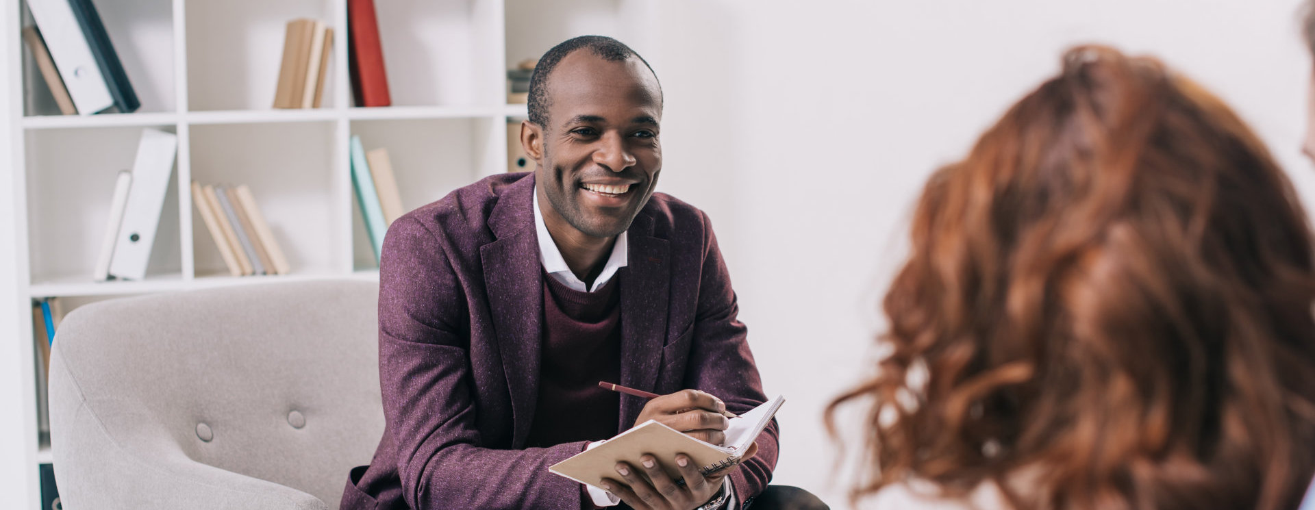 Smiling african american psychiatrist talking to young couple