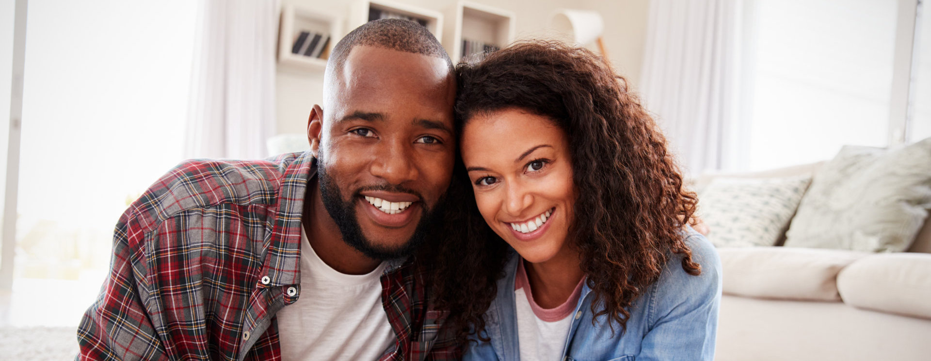 Portrait Of Couple Lying On Rug In Lounge At Home